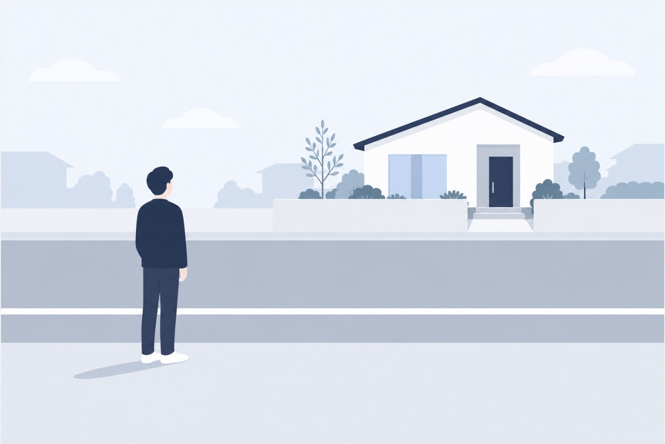 道路上の白い境界線の手前に立つ人物のシルエットと、線の向こう側にある住宅のイラスト
